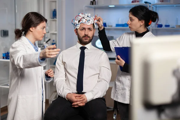 Equipe médica de cientistas ajustando eeg cérebro analisando a evolução do sistema nervoso — Fotografia de Stock