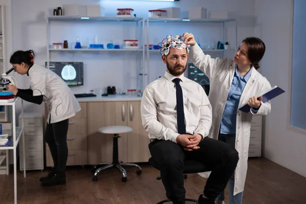 Forscher Neurologin Frau Anpassung eeg Headset Überwachung der Gehirnaktivität des Mannes Patient — Stockfoto