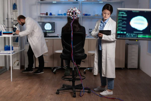 Neurologo ingegnere medico monitorare l'evoluzione dell'attività cerebrale durante l'esperimento di neuroscienza — Foto Stock