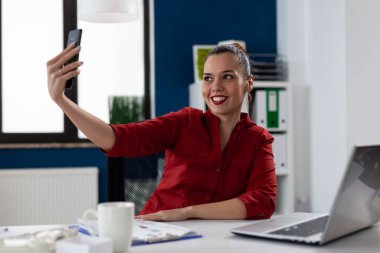 Kırmızı gömlekli girişimci ofiste selfie çekiyor..
