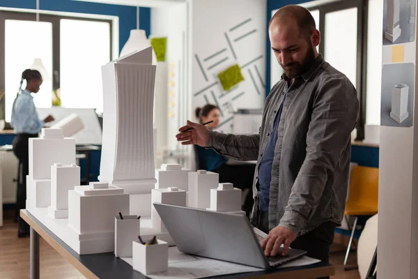 Arhitectural designer i videokonferens presenterar vitt skum byggnad modell — Stockfoto