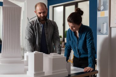 Mimarlık mühendisleri takım çalışması yaparak inşaat planlarını okuyorlar.