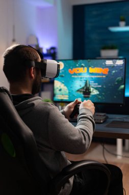 Denetleyici ve vr gözlüğü kullanan, video oyunları oynayan kişi