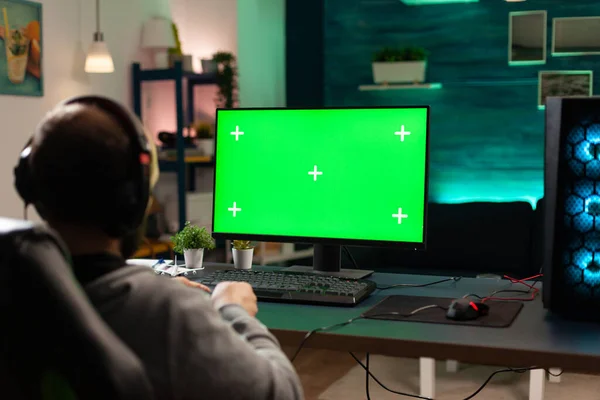 Gracz patrzy na komputer z poziomym zielonym ekranem — Zdjęcie stockowe