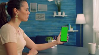 İş kadını oturma odasında modern telefon kullanarak ofis masasında oturuyor.