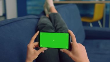 İş kadını kanepeye uzanmış, izole bir telefon tutuyor.
