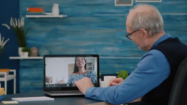 Feliz hombre mayor saludando durante la videoconferencia con sobrinos utilizando el ordenador portátil — Vídeos de Stock