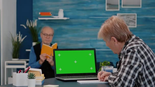Senior vrouw op zoek naar groene scherm monitor werken vanuit huis — Stockvideo