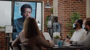 Yüz maskesi olan insanlar görüntüde uzak video konferansı kullanıyor