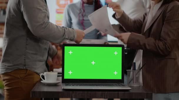Εργάτες με χαρτιά που χρησιμοποιούν πράσινη οθόνη στο laptop — Αρχείο Βίντεο