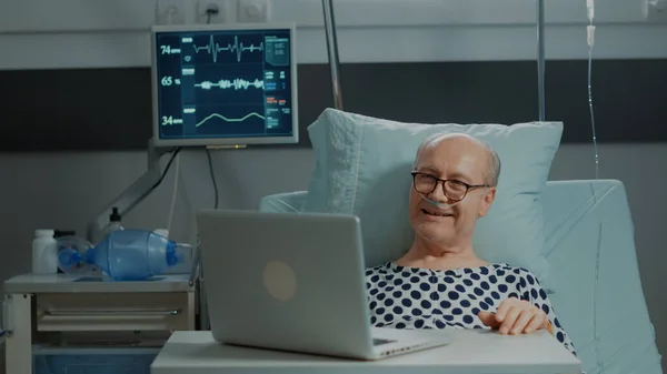 Oudere patiënt in gesprek op videocall in ziekenhuisafdeling — Stockfoto
