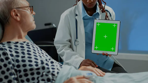 Femme chirurgienne tenant un comprimé à écran vert dans la salle d'hôpital — Photo