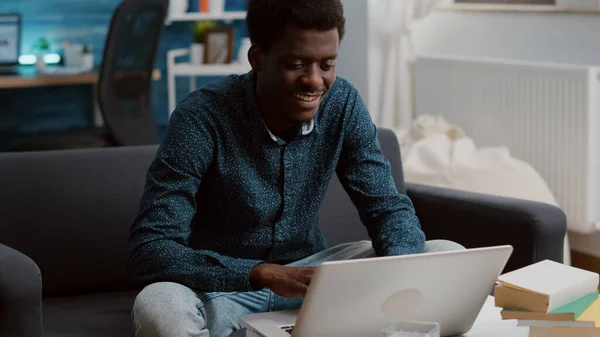 Auténtico sonriente negro afroamericano chico trabajando desde casa en su computadora portátil —  Fotos de Stock