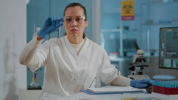 Mujer científica mirando muestras de sangre en bandeja en laboratorio —  Fotos de Stock