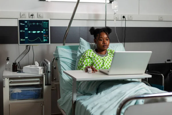 Doente afro-americano em pé na cama durante consulta médica — Fotografia de Stock