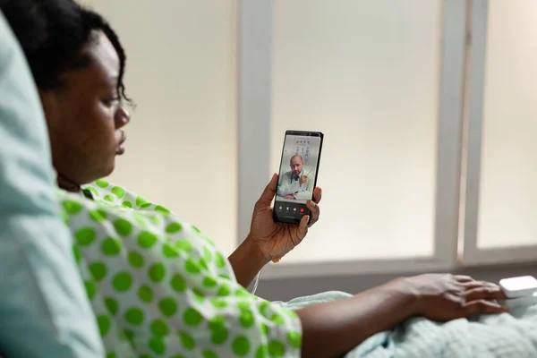 African american young patient holding smartphone discussing medication treatment — Stock Photo, Image