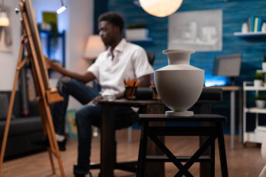 İlham almak için sandalyenin üzerinde duran beyaz vazoya odaklan