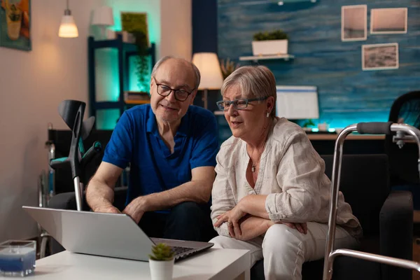 Gepensioneerd paar op zoek naar moderne laptop op tafel — Stockfoto