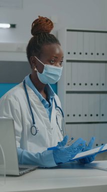 Doktor kontrol kağıtlarına bilgi yazıyor.