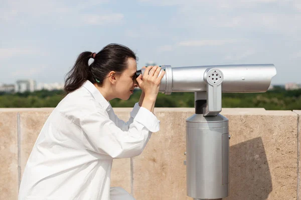 Mulher bonita olhando através de telescópio binocular turístico — Fotografia de Stock