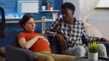 Irklar arası bir çift oturma odasında çocuk bekliyor.