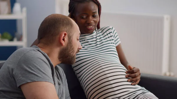 Kanepede oturan hamile Afro-Amerikan kadının fotoğrafını çek. — Stok fotoğraf