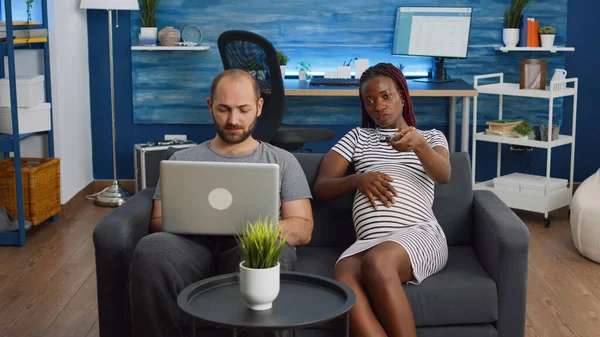 Smíšené rasy lidé sedí spolu na pohovce čeká dítě — Stock fotografie
