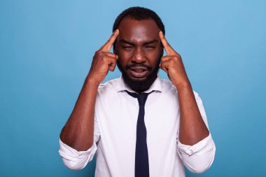 Yorgun bir ofis çalışanı baş ağrısı çekiyor. Tapınakta gerginlik var.