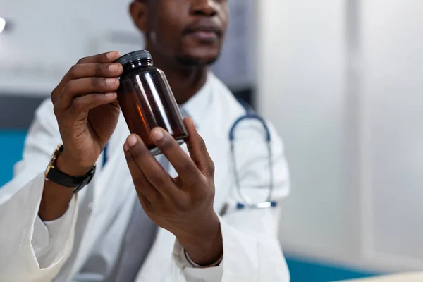 Close-up van de Afrikaanse Amerikaanse kinderarts arts met pillen fles in de hand — Stockfoto