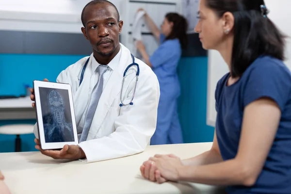 Médico pediatra afroamericano explicando radiografía ósea a la madre —  Fotos de Stock