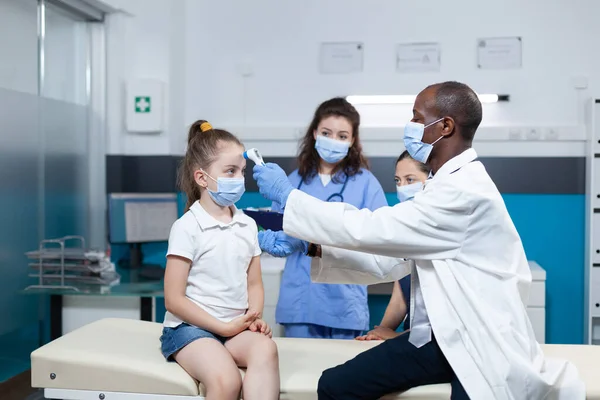 Médico pediatra afroamericano con mascarilla facial contra covid19 — Foto de Stock