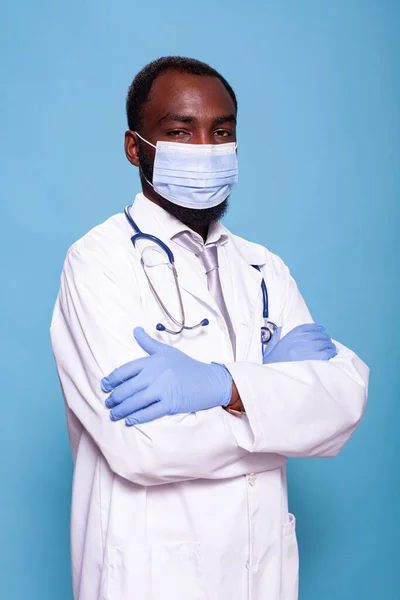 Ritratto verticale di medico fiducioso con braccia incrociate indossando maschera e guanti in lattice — Foto Stock