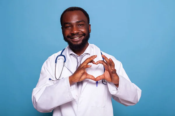 Cardiologia sorridente médico fazendo forma do coração com as mãos — Fotografia de Stock