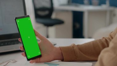 Cep telefonunda yeşil ekranı dikey olarak tutan eli kapat