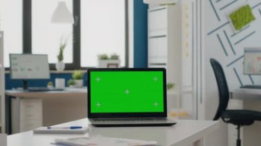 Boş ofiste yeşil ekranlı dizüstü bilgisayarı kapat