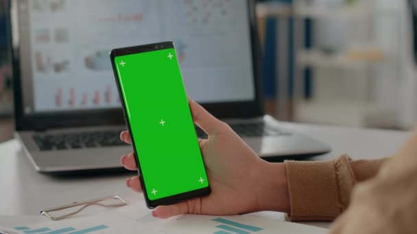 Primer plano de la mujer sosteniendo la pantalla verde aislada verticalmente en el teléfono — Vídeos de Stock