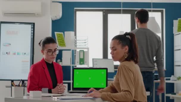 Compagni di lavoro seduti alla scrivania e utilizzando lo schermo verde sul computer portatile — Video Stock