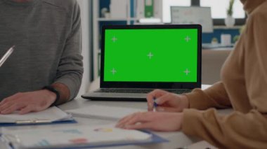 Laptopta yeşil ekranla çalışan insanları kapat