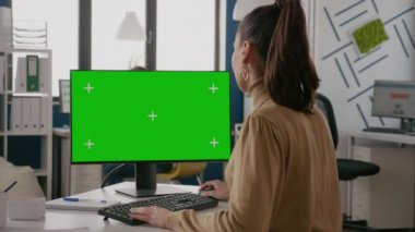Yeşil ekranlı monitör kullanan iş kadını