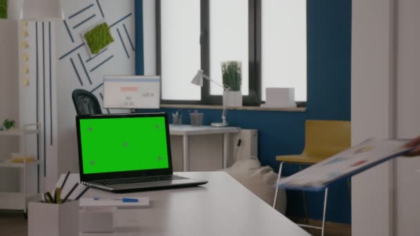 Woman sitting at desk with green screen on laptop — Stockvideo