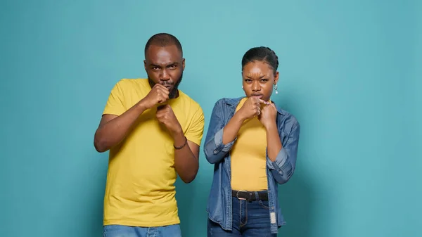 African american couple punching air with fists in front of camera — Stock Photo, Image