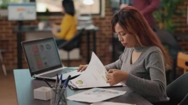 Asyalı kadın finansal analiz yaratmak için dizüstü bilgisayarda çalışıyor.