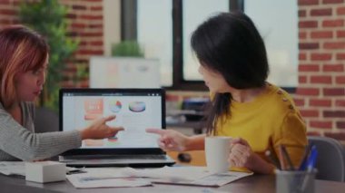 Dizüstü bilgisayardaki iş grafiklerine bakan meslektaşlar