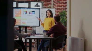 Sunumda grafik ve grafikleri açıklayan Asyalı kadın