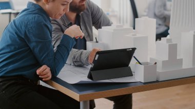 Tablet ve inşa modelleri ile çalışan çalışma arkadaşlarının inşaat düzenini kapat
