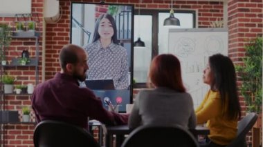 Toplantı odasında görüntülü konuşma kullanan bir grup iş arkadaşı.