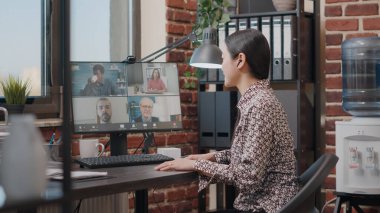 İş kadını, iş arkadaşlarıyla proje hakkında konuşmak için video çağrısı yapıyor.