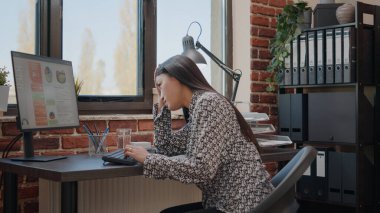 Çalışan, proje üzerinde çalışırken baş ağrısıyla uğraşıyor.