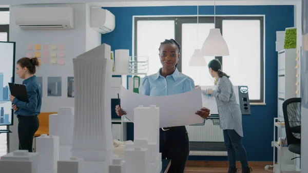 Retrato de mujer arquitecta analizando planos planos sobre papel para diseñar modelo de edificio — Foto de Stock