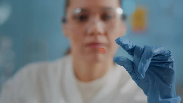 Mujer bióloga analizando muestra de sangre en bandeja de vidrio — Foto de Stock